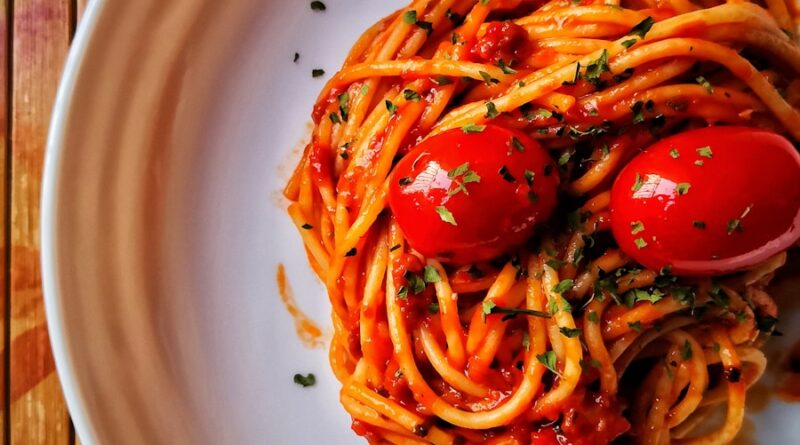 a white plate topped with spaghetti and tomatoes