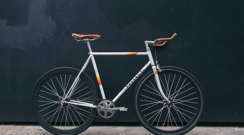 gray fixie bike leaning on black wall